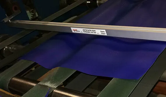 Antistatic bar mounted above the material surface on a production line